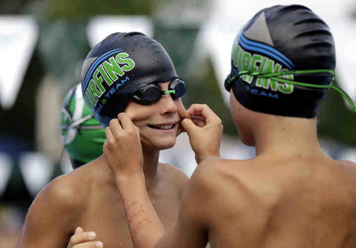 Dublin Muirfield's Brady Delmore (right) pinches teammate Brayden Swenson's cheeks before their heat in the age 9-10, 100-meter freestyle relay at the NEW League Championships at Dublin Community Pool North.  (Shane Flanigan / ThisWeek Community News)